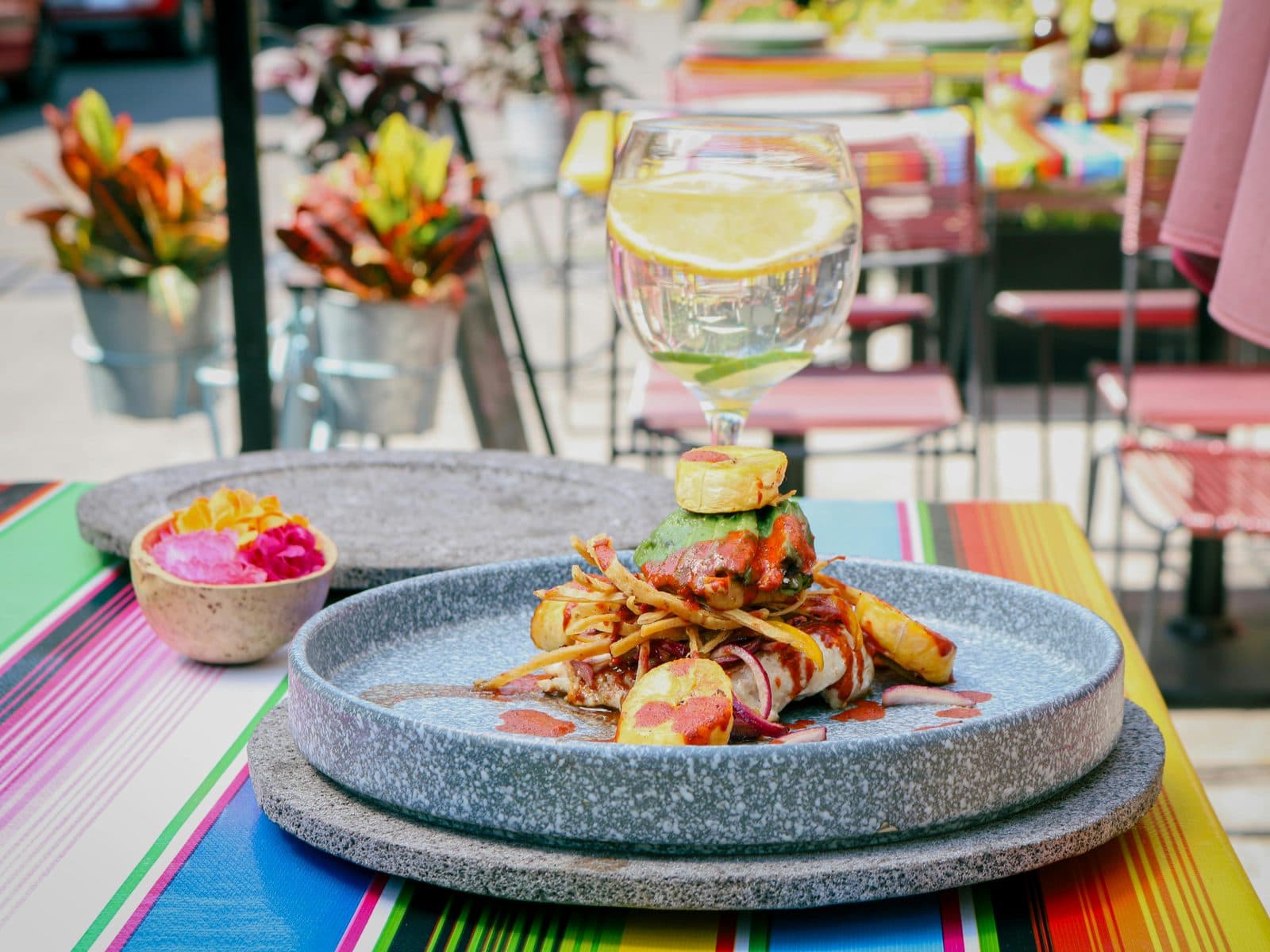 Plato de la cocina costeña servido en un restaurante, con plátano, guacamole y salsas